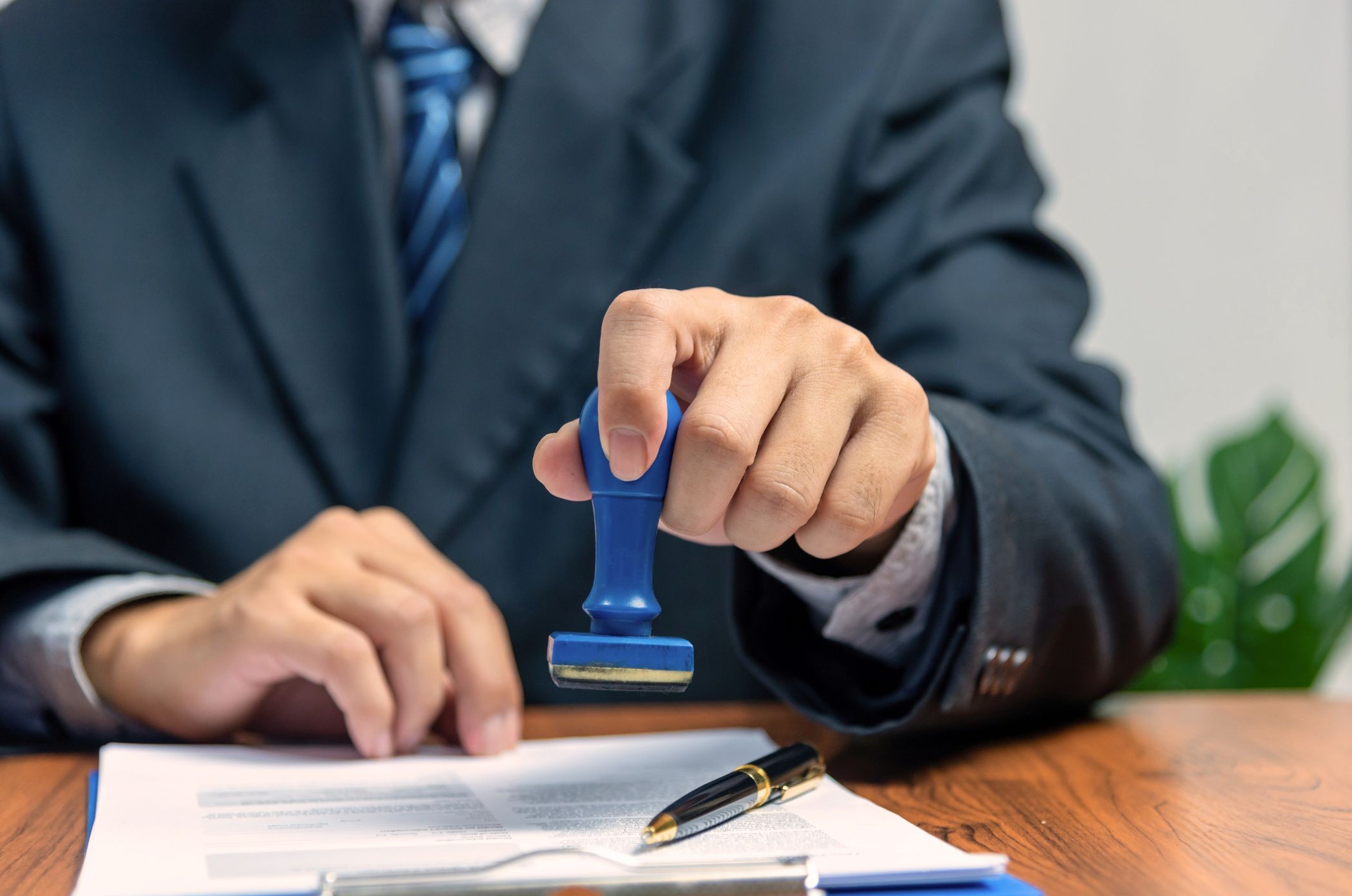 A government worker stamping documents for transfer of shares.
