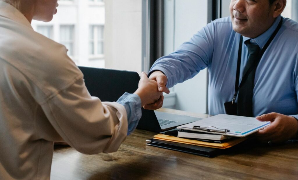 banker and customer shaking hands after an interview.