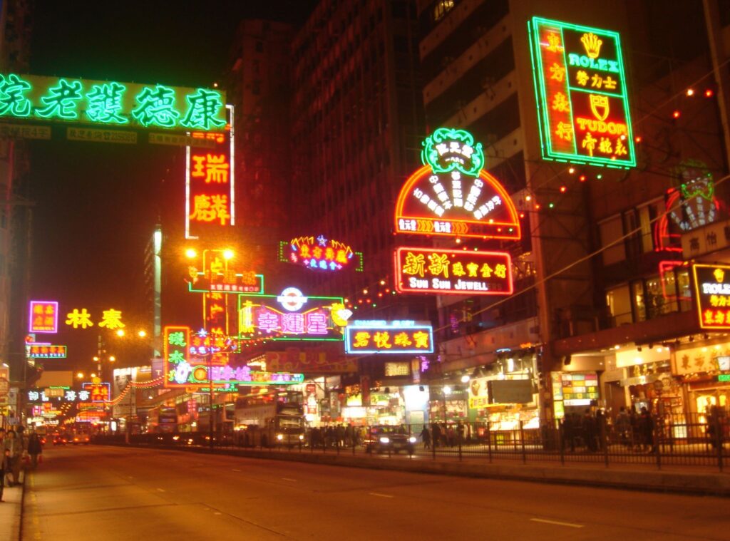 Lit up neon signs on a Hong Kong street at night supported by The CreateSmart Initiative (CSI). 