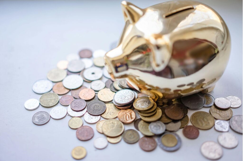 Coins strewn around a piggy bank, a symbol of savings in your retirement fund MPF in Hong Kong.